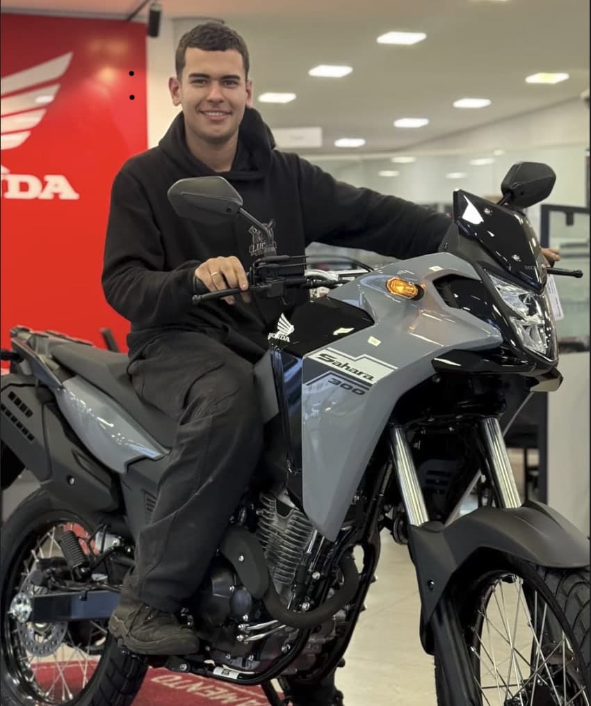 Kauã Angelo ao lado da Honda Sahara 300 0 km, no dia da compra.